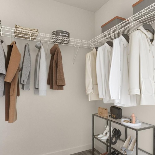 Closet space with shelves and ample lighting a room with a rack of clothes